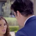 Ângela e Leonardo se olham com amor, enquanto Álvaro observa com amargura ao fundo.