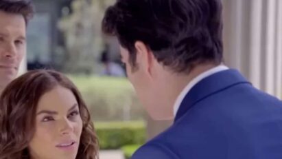 Ângela e Leonardo se olham com amor, enquanto Álvaro observa com amargura ao fundo.