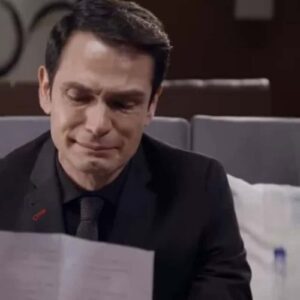 Dário chora enquanto lê a carta de Sandro, seus olhos marejados de emoção e tristeza.