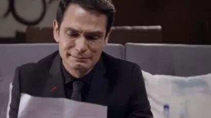 Dário chora enquanto lê a carta de Sandro, seus olhos marejados de emoção e tristeza.