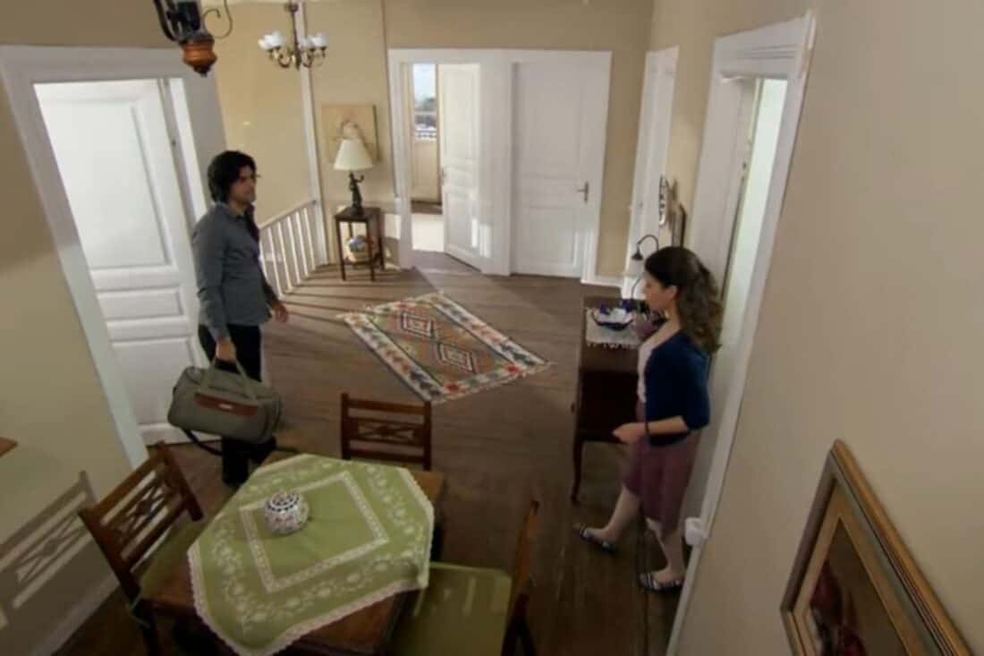 Fatmagül e Kerim em um momento de tensão, com Fatmagül demonstrando tristeza e Kerim com expressão séria