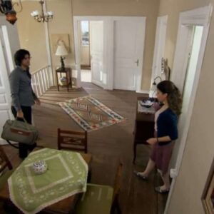 Fatmagül e Kerim em um momento de tensão, com Fatmagül demonstrando tristeza e Kerim com expressão séria