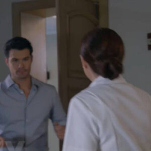 Ângela, com olhar triste e abatido, segura seus pertences enquanto sai da casa de Leonardo.