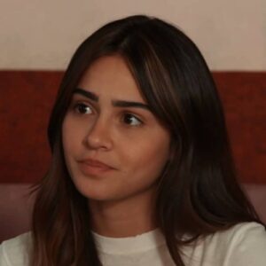 Sandra chora em uma cama de hospital, com o rosto abatido pela dor.