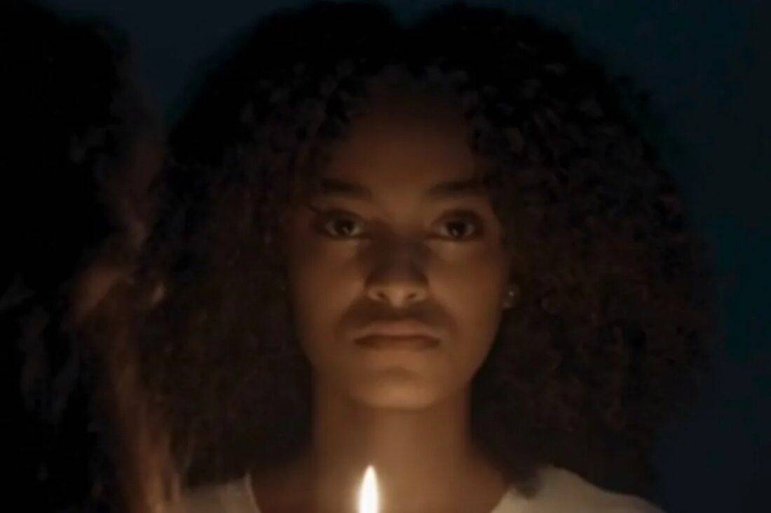 Teca de olhos revirados e com expressão intensa, em estado de transe durante a manifestação de Exu.