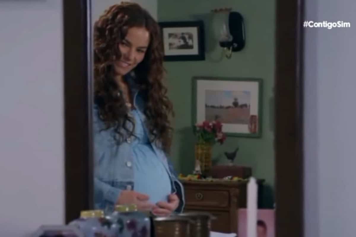 Ângela grávida, com um olhar de surpresa e preocupação.