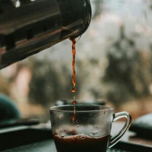 Café sendo preparado: Imagem de uma xícara de café fresco sendo servido.