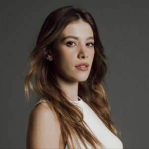 Caroline Dallarosa preparando uma receita na cozinha, com um sorriso no rosto.