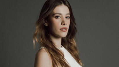 Caroline Dallarosa preparando uma receita na cozinha, com um sorriso no rosto.