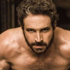 Foto de Caco Ciocler sorrindo em um evento público.