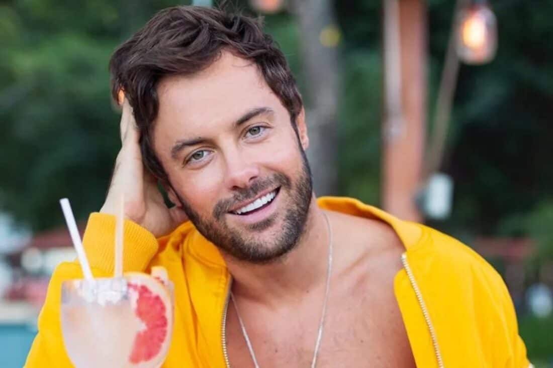 Imagem de Kayky Brito com um sorriso no rosto, em uma pose descontraída