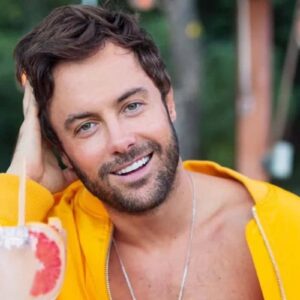 Imagem de Kayky Brito com um sorriso no rosto, em uma pose descontraída