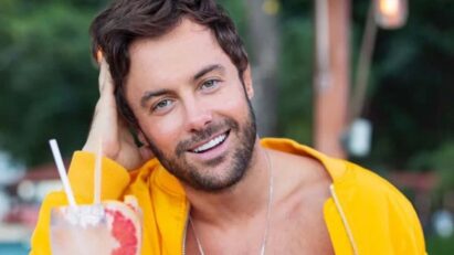 Imagem de Kayky Brito com um sorriso no rosto, em uma pose descontraída