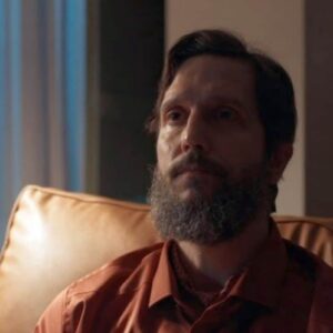 Uma imagem de Egídio com uma expressão maléfica no rosto e Marçal amarrado em uma cadeira com chamas ao fundo.