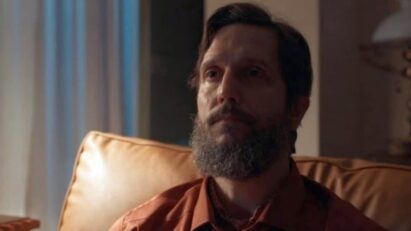 Uma imagem de Egídio com uma expressão maléfica no rosto e Marçal amarrado em uma cadeira com chamas ao fundo.