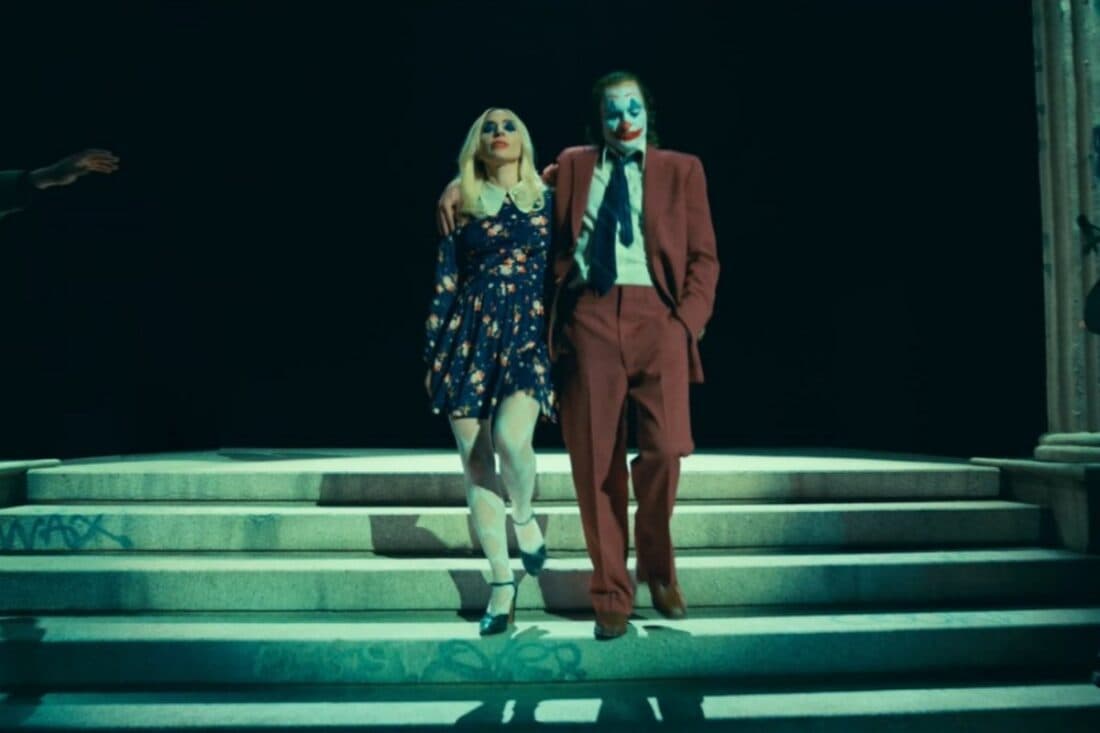 Cena do trailer de "Coringa: Delírio a Dois" mostrando Coringa e Arlequina lado a lado em um ambiente sombrio e caótico