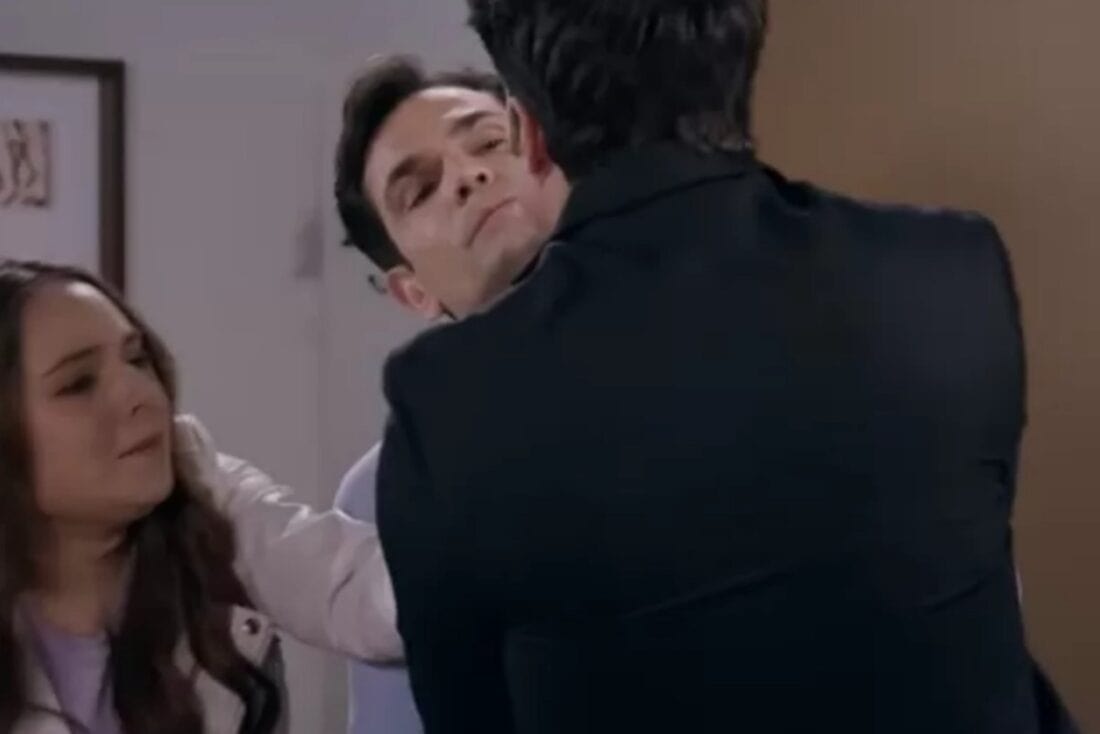 Cena de Contigo Sim mostrando Dário e Clarinha se beijando. Álvaro aparece ao fundo, entrando no quarto sem querer e com uma expressão de choque no rosto.