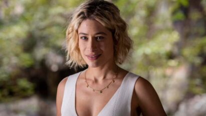 Blandina sorrindo de forma maliciosa, enquanto observa Quinota e Artur em uma situação tensa