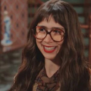 Imagem de Lupita antes de sua transformação, com seu visual simples e característico.