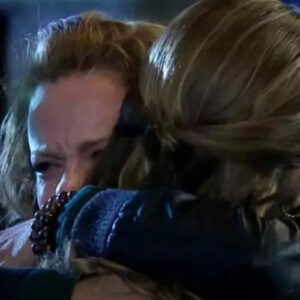 Imagem de Renata e Regina se abraçando emocionadas no jardim, após a revelação de que são mãe e filha