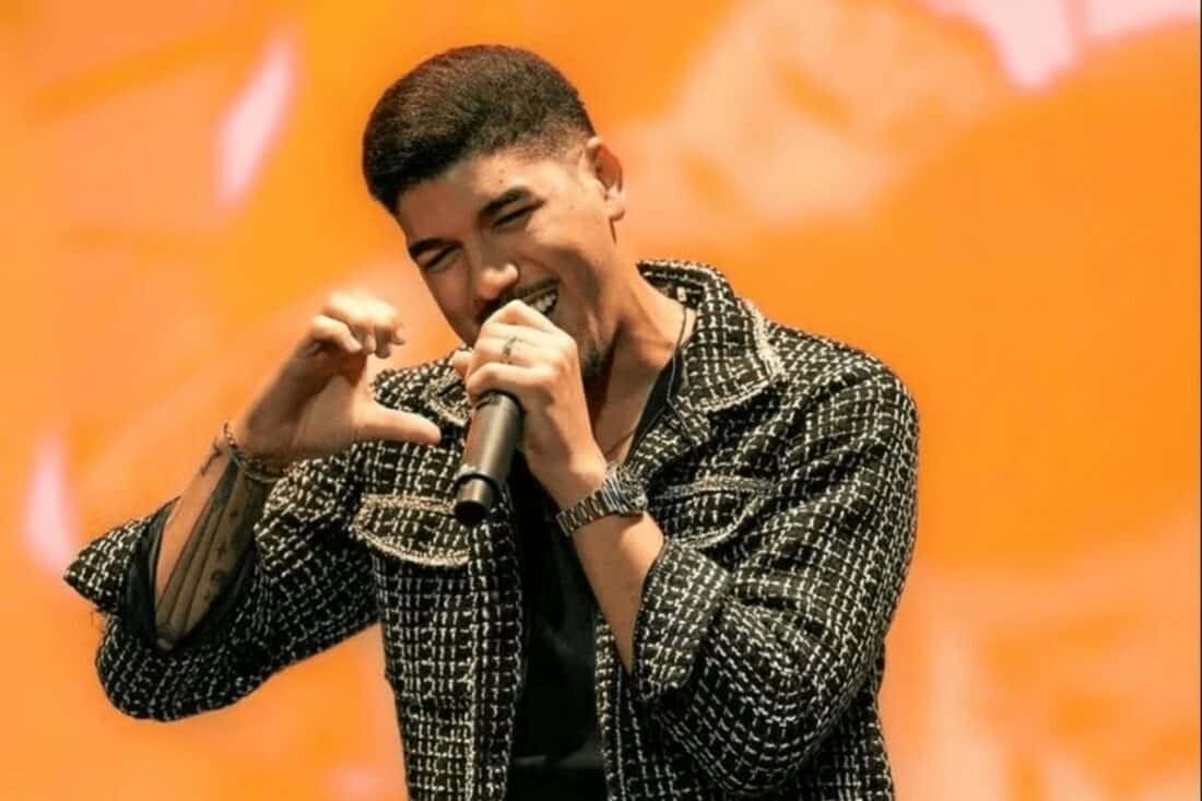 Imagem de Zé Vaqueiro em uma apresentação ao vivo, capturando o cantor em um momento de alta energia no palco.