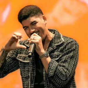 Imagem de Zé Vaqueiro em uma apresentação ao vivo, capturando o cantor em um momento de alta energia no palco.