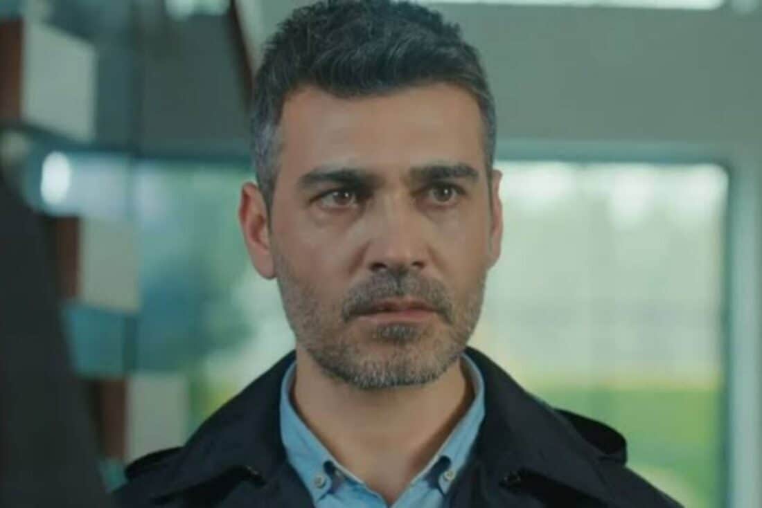 Sarp observando Julide e Suat em conversa suspeita na novela Força de Mulher