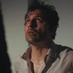 Arif amarrado em uma cadeira, com marcas de agressão no rosto.