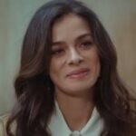 Uma foto de Bahar com um novo visual, mais maquiada e com um sorriso radiante.
