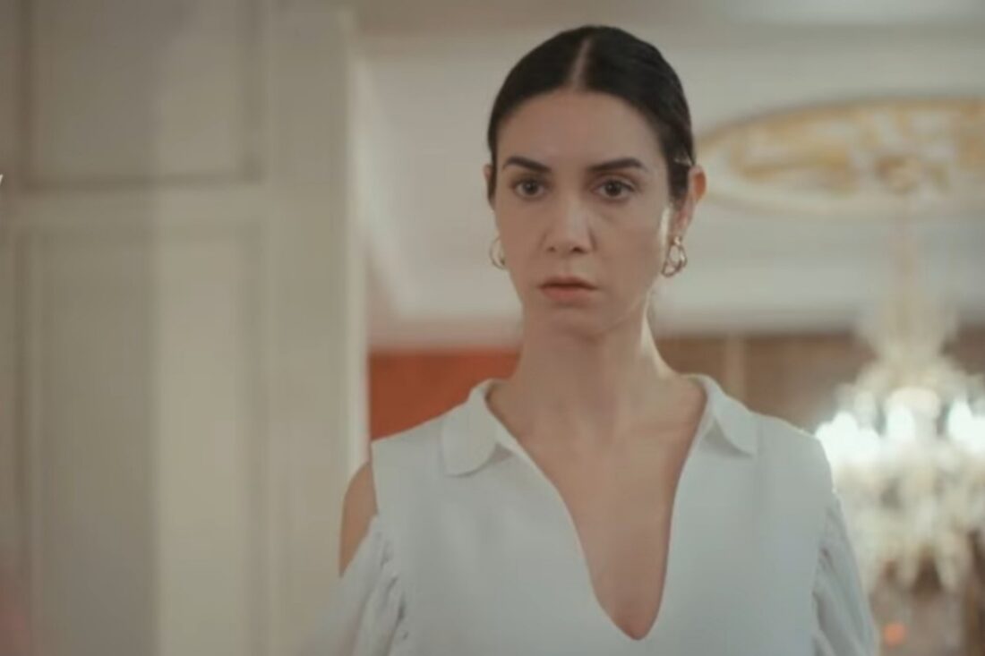 Cena da novela Força de Mulher, mostrando Piril pensativa, segurando o celular com a tela iluminada, demonstrando seu dilema.