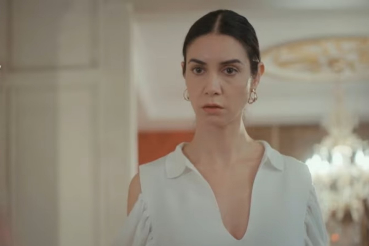 Cena da novela Força de Mulher, mostrando Piril pensativa, segurando o celular com a tela iluminada, demonstrando seu dilema.