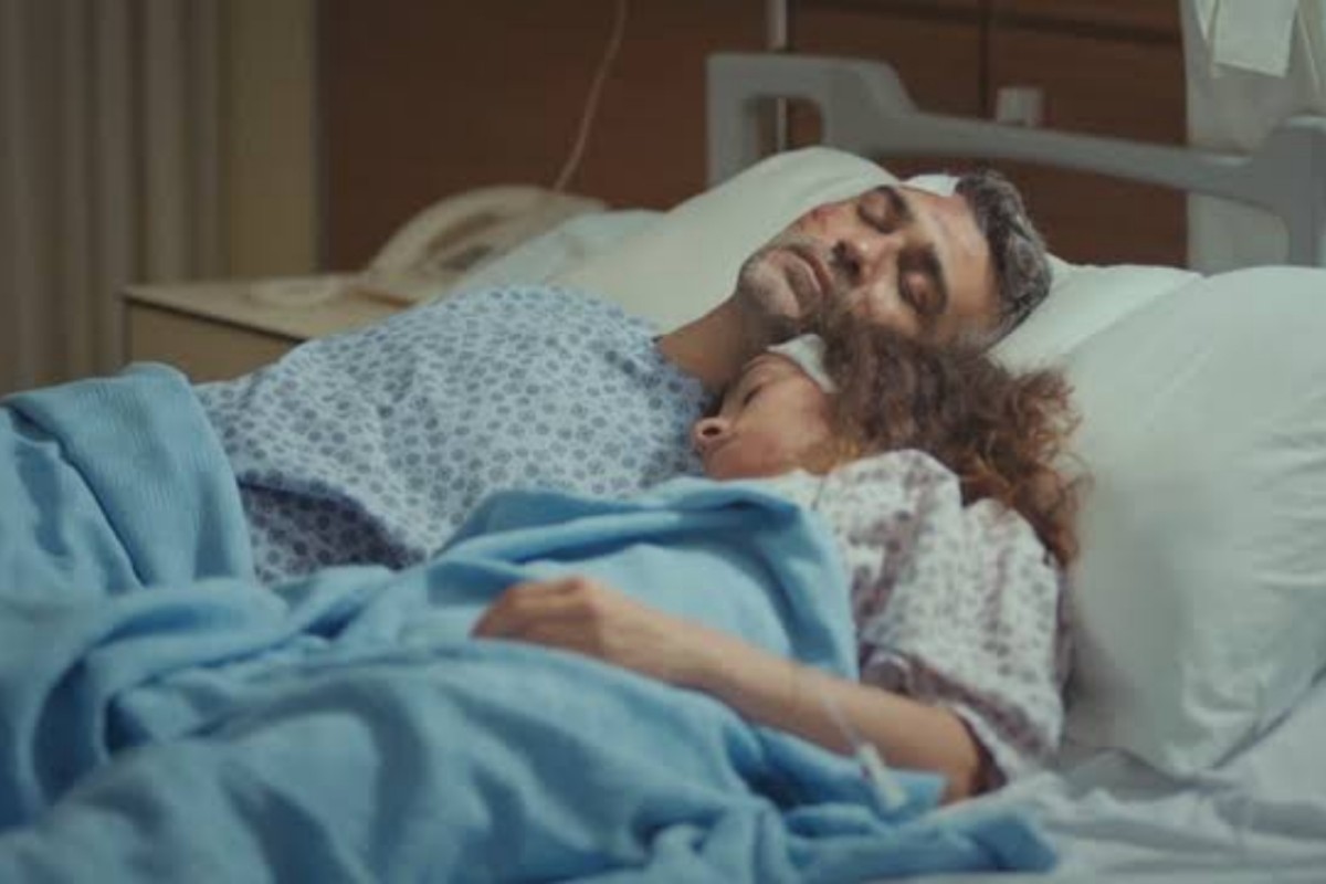 Bahar e Sarp deitados juntos no hospital, demonstrando reconciliação