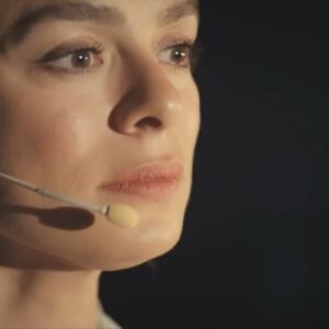 Bahar emocionada em palestra enquanto relembra acidente com Sarp e Hatice em Força de Mulher.