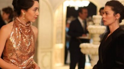 Bahar e Kismet trocando olhares tensos durante o evento em Força de Mulher, cena que revela conexão inesperada entre as personagens.