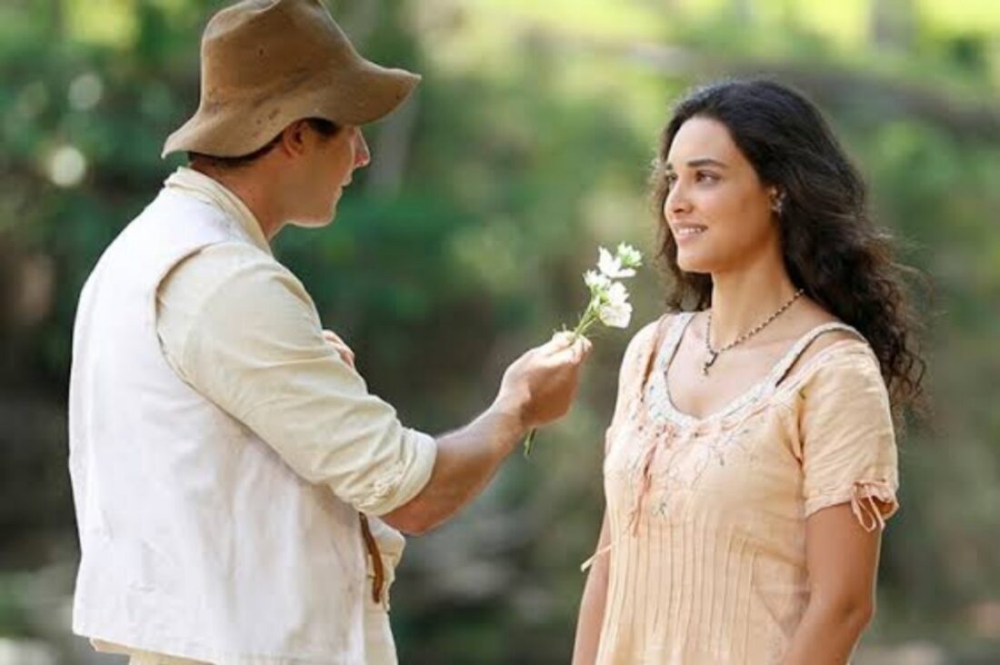 alt="Filó (Débora Nascimento) em cena de 'Êta Mundo Bom', talvez com Candinho, sorrindo."