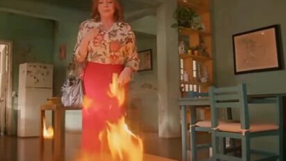 Ofélia observa o incêndio consumindo sua casa com expressão fria, enquanto Valéria e Artur correm desesperados em "As Filhas da Senhora Garcia".