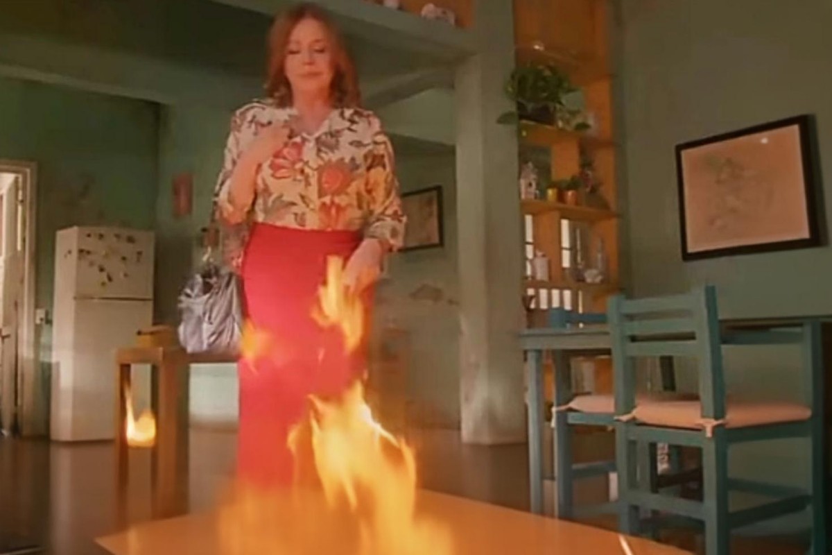 Ofélia observa o incêndio consumindo sua casa com expressão fria, enquanto Valéria e Artur correm desesperados em "As Filhas da Senhora Garcia".