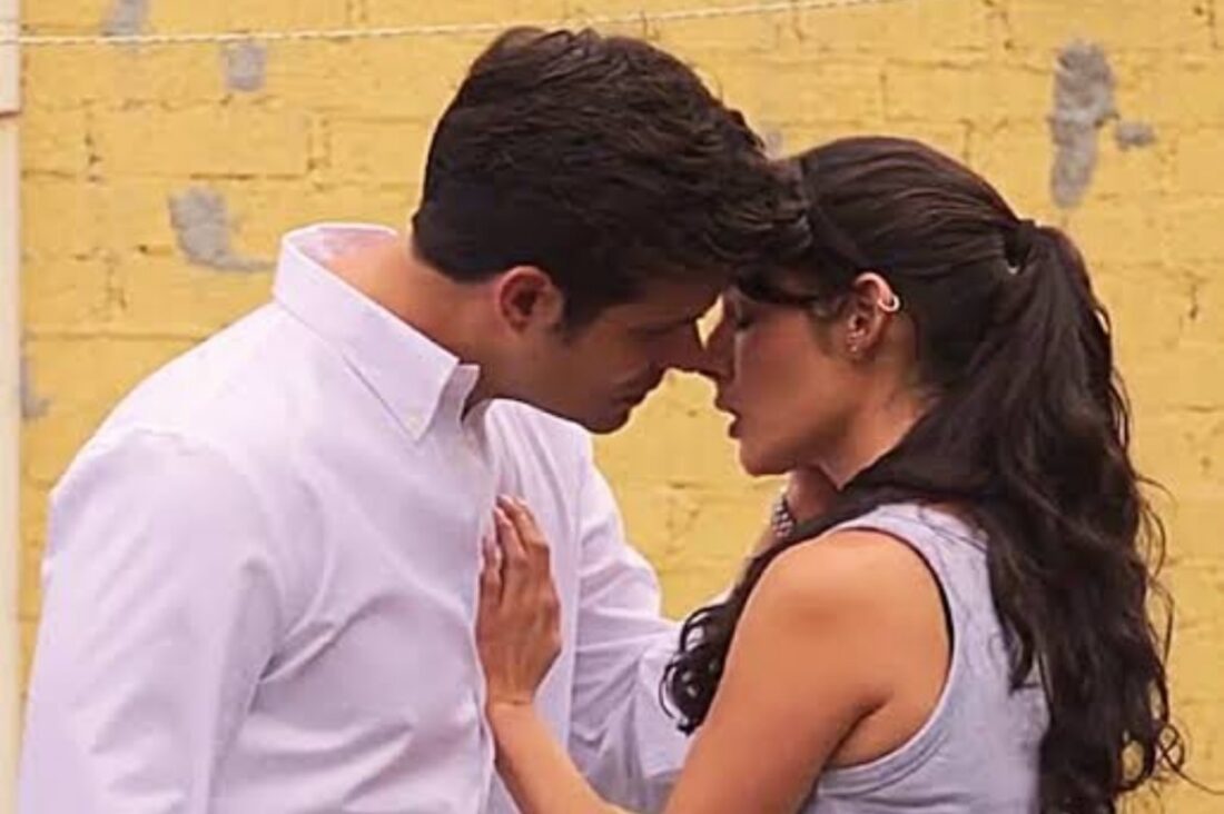 Valéria e Artur trocam olhares intensos enquanto conversam no jardim, momentos antes da promessa inesperada.