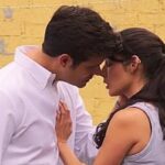 Valéria e Artur trocam olhares intensos enquanto conversam no jardim, momentos antes da promessa inesperada.