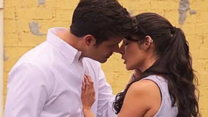 Valéria e Artur trocam olhares intensos enquanto conversam no jardim, momentos antes da promessa inesperada.