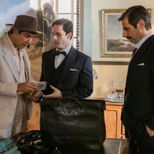 Candinho (Sérgio Guizé) observando Celso e Araújo