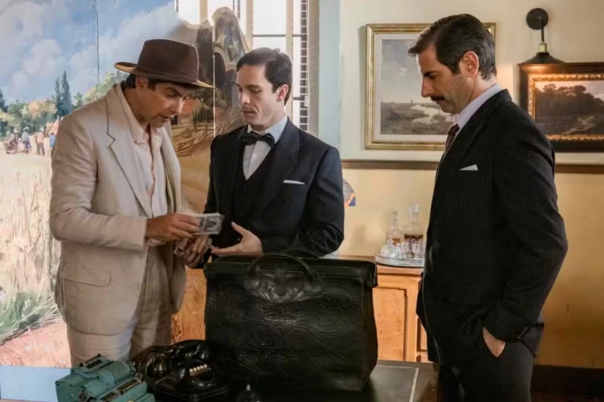 Candinho (Sérgio Guizé) observando Celso e Araújo