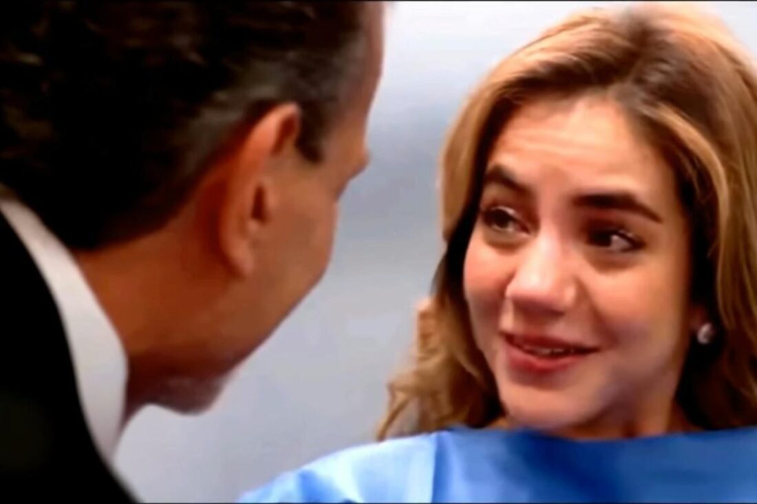 Mãe emocionada segura a mão do marido durante exame de ultrassom.”