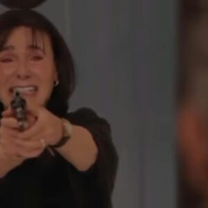 Rosa armada na mansão, prestes a atirar