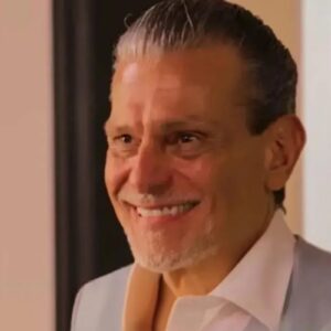 Luiz emocionado diante do mural com fotos da família