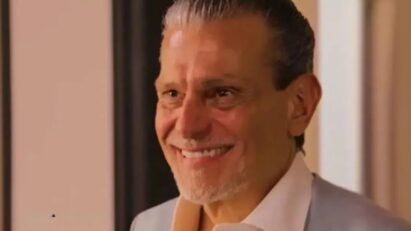 Luiz emocionado diante do mural com fotos da família